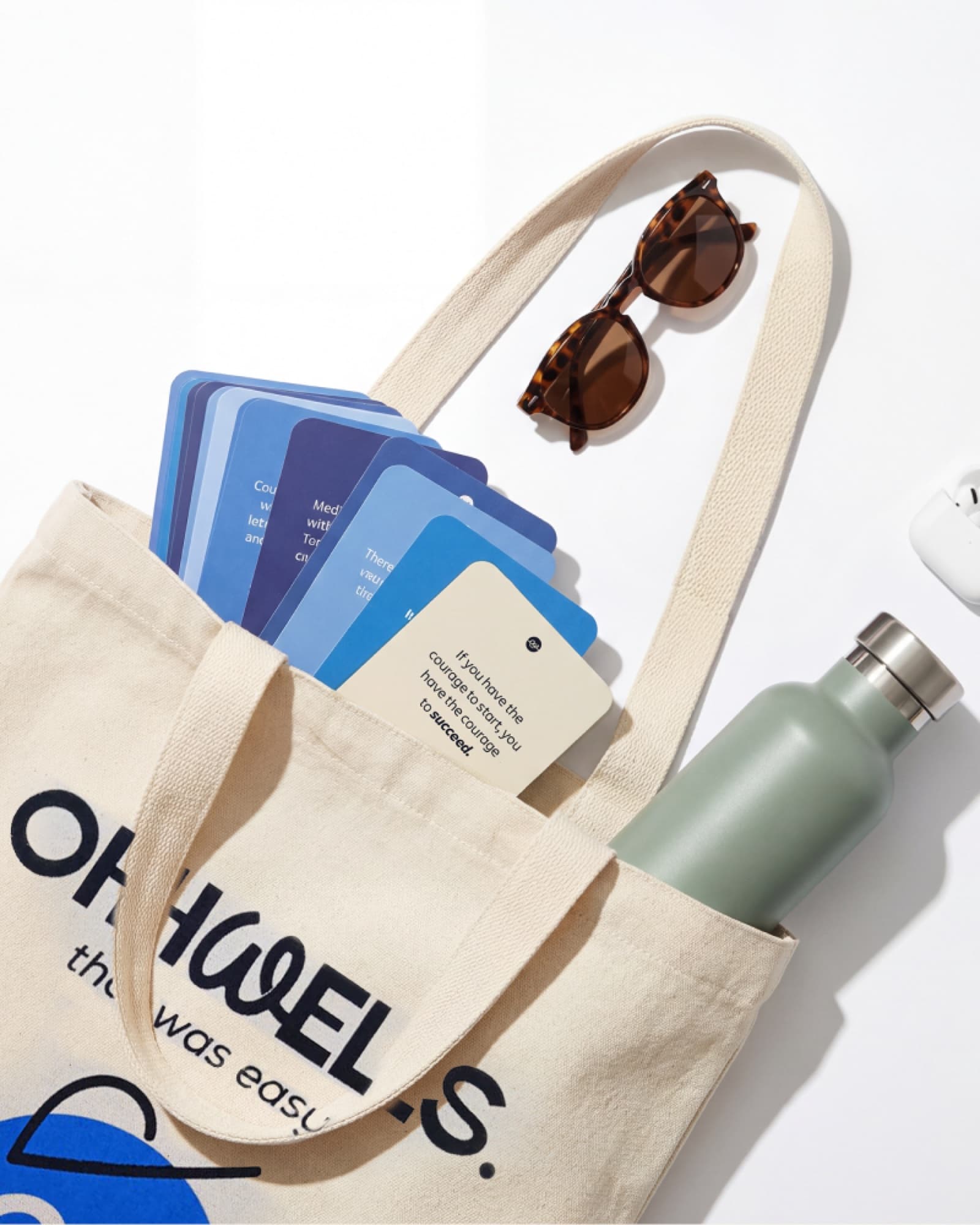OhhWells tote bag with affirmation cards, sunglasses, and water bottle